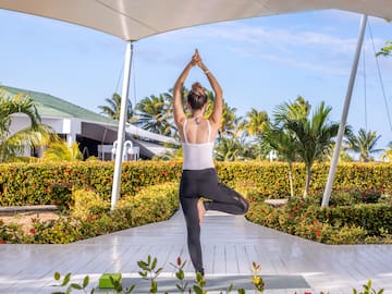 a woman standing on one leg with arms raised in the air