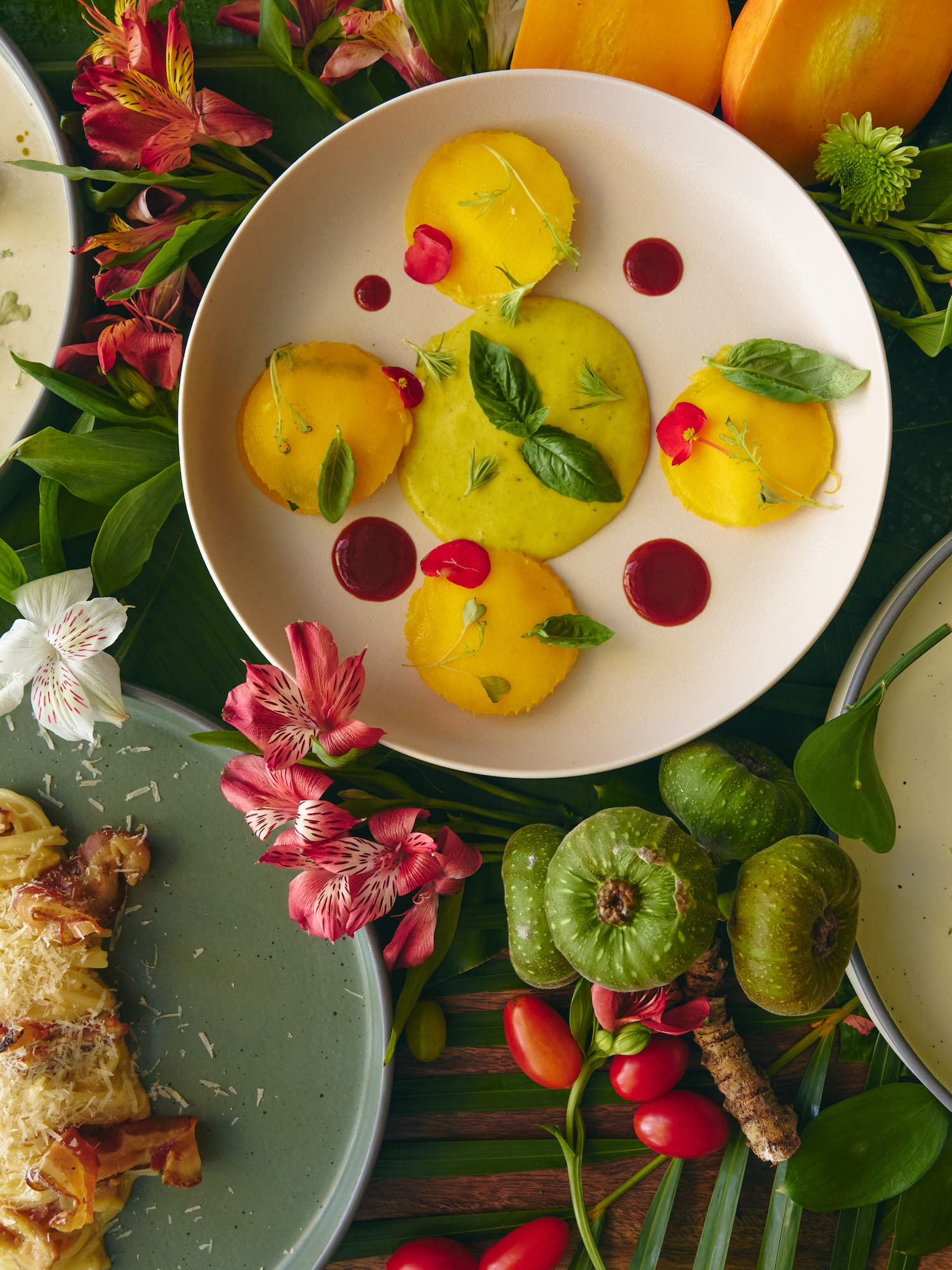 Exquisite gourmet meal presentation: soup, savory polenta, carbonara, steak, tropical setting.