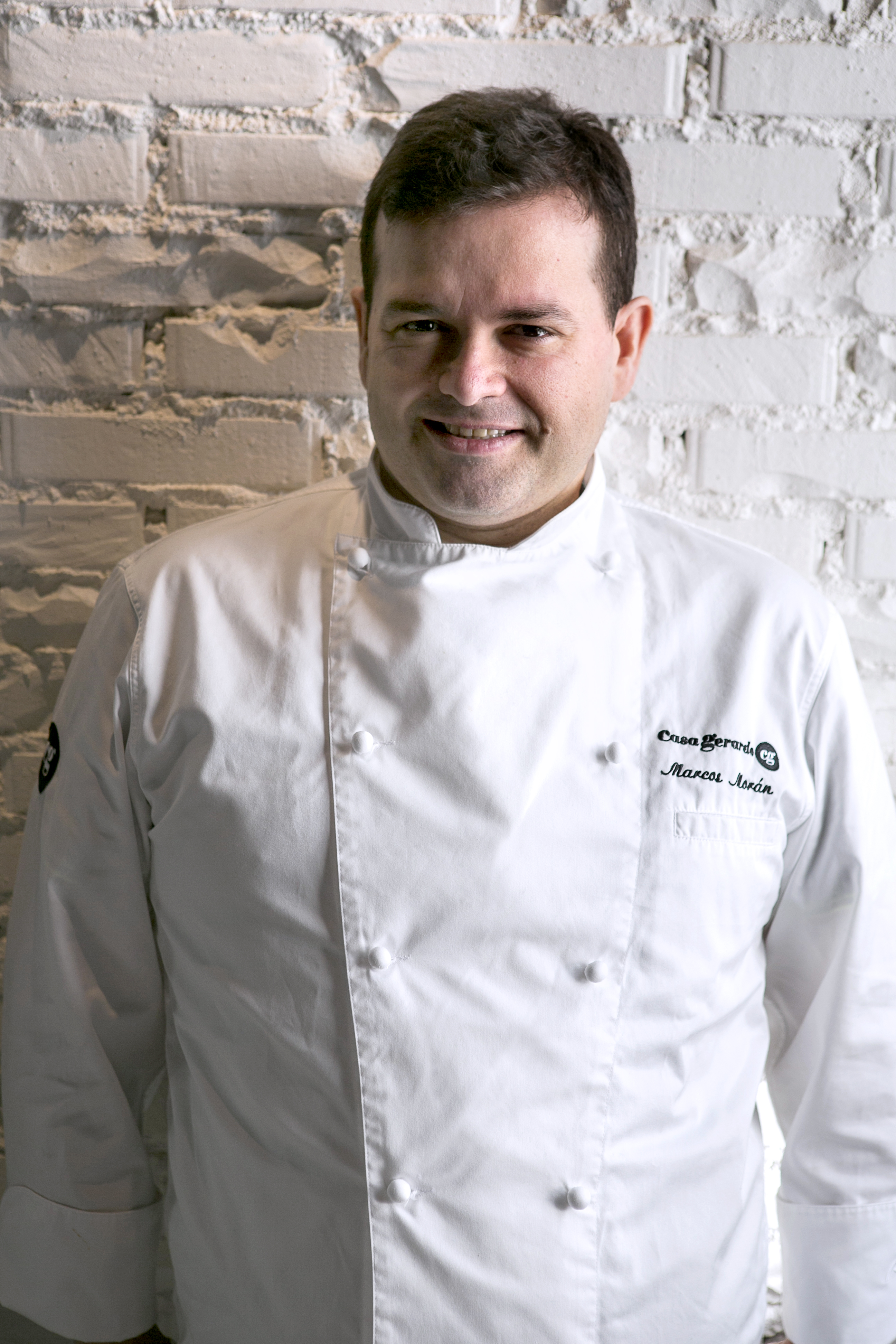 Chef Marcos Morán from Casa Gerardo smiling in white uniform.