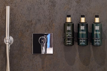 a group of green bottles next to a silver mirror