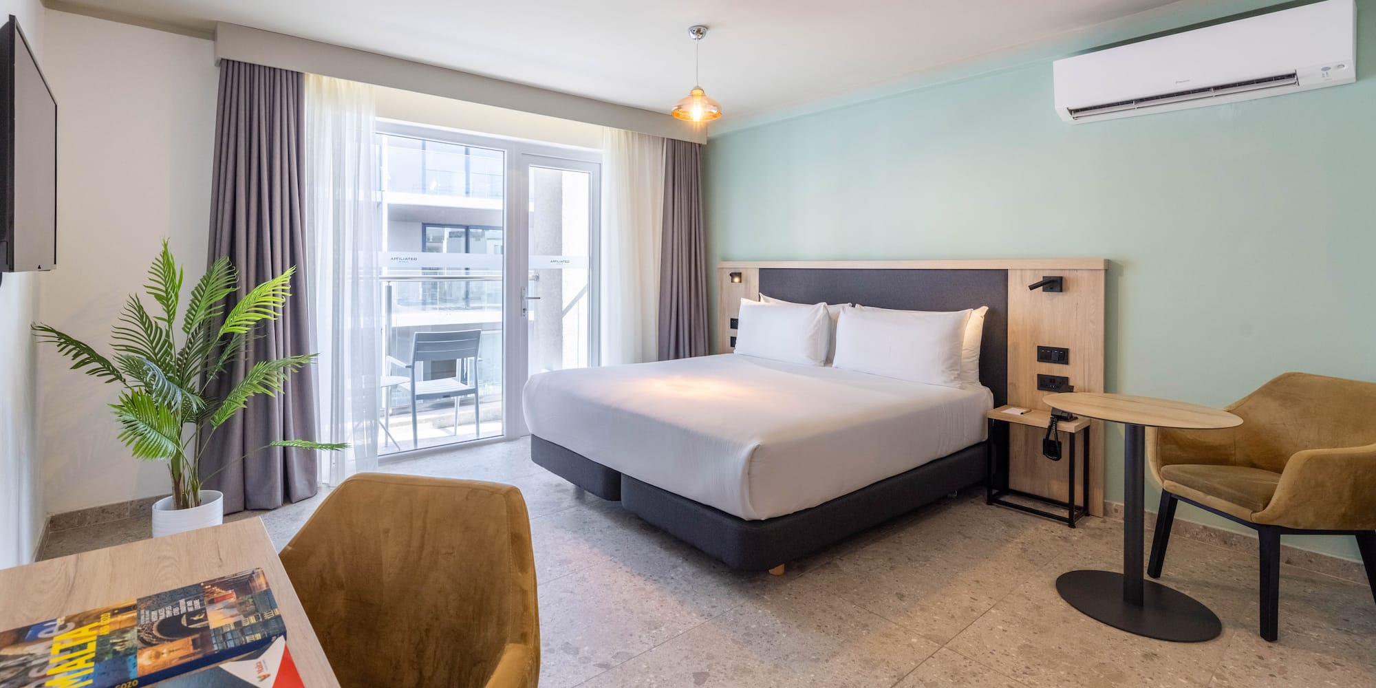 a room with a bed and a table and a plant