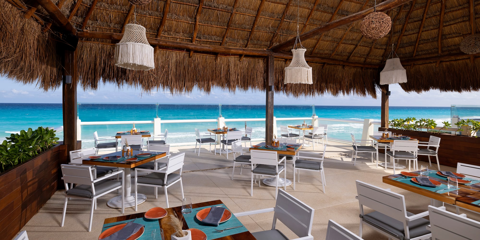 a restaurant with a thatched roof and tables and chairs