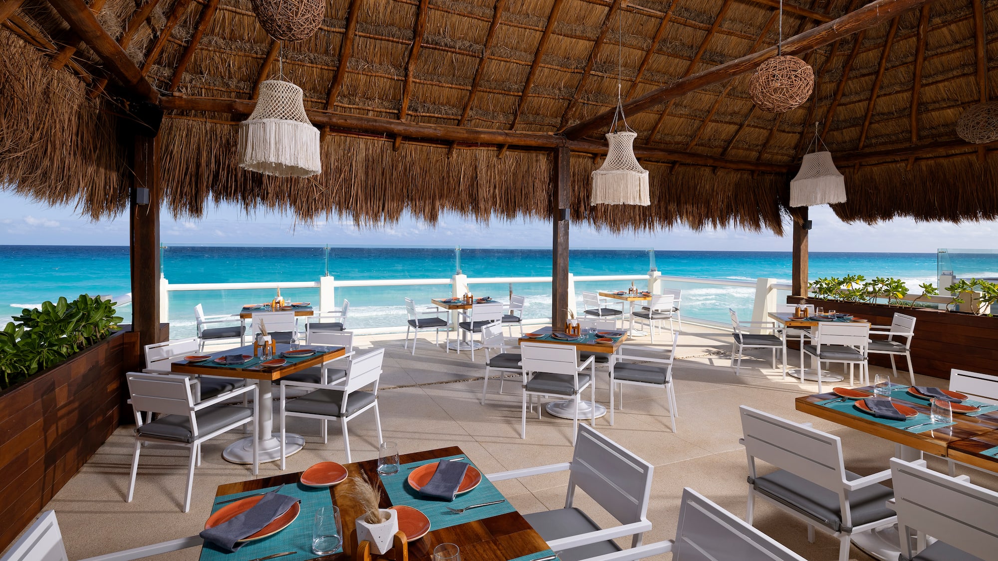 a restaurant with a thatched roof and tables and chairs