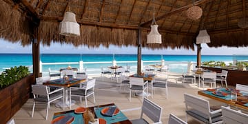 a restaurant with a thatched roof and tables and chairs