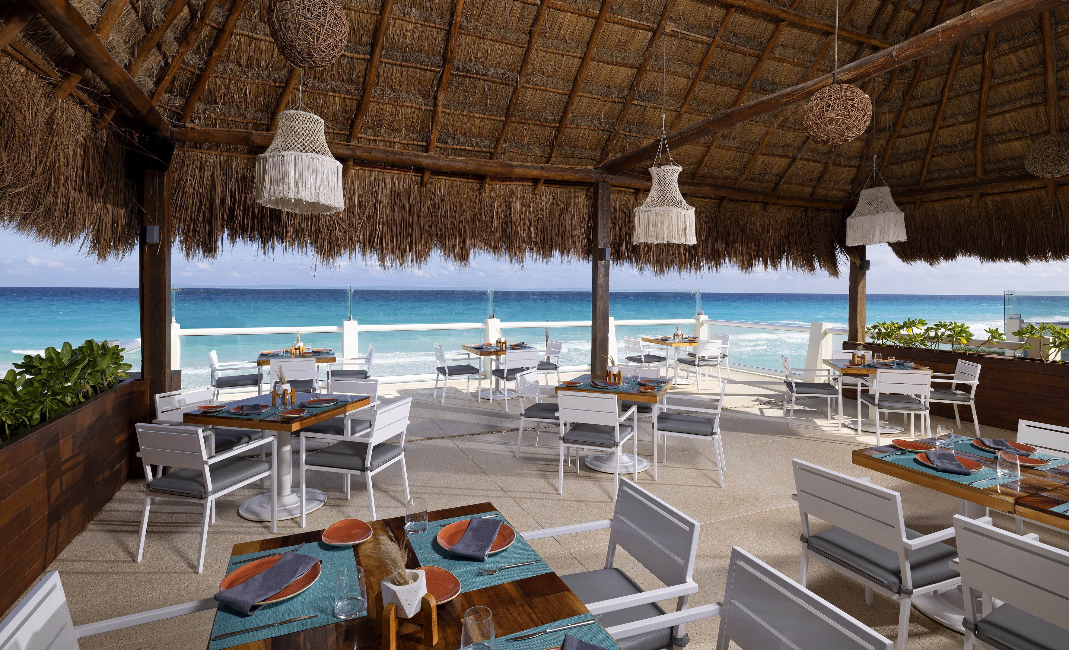 a restaurant with a thatched roof and tables and chairs