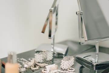 a mirror and jewelry on a counter