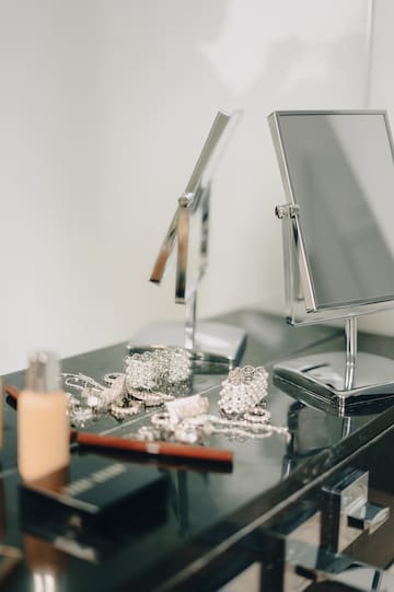 a mirror and jewelry on a counter