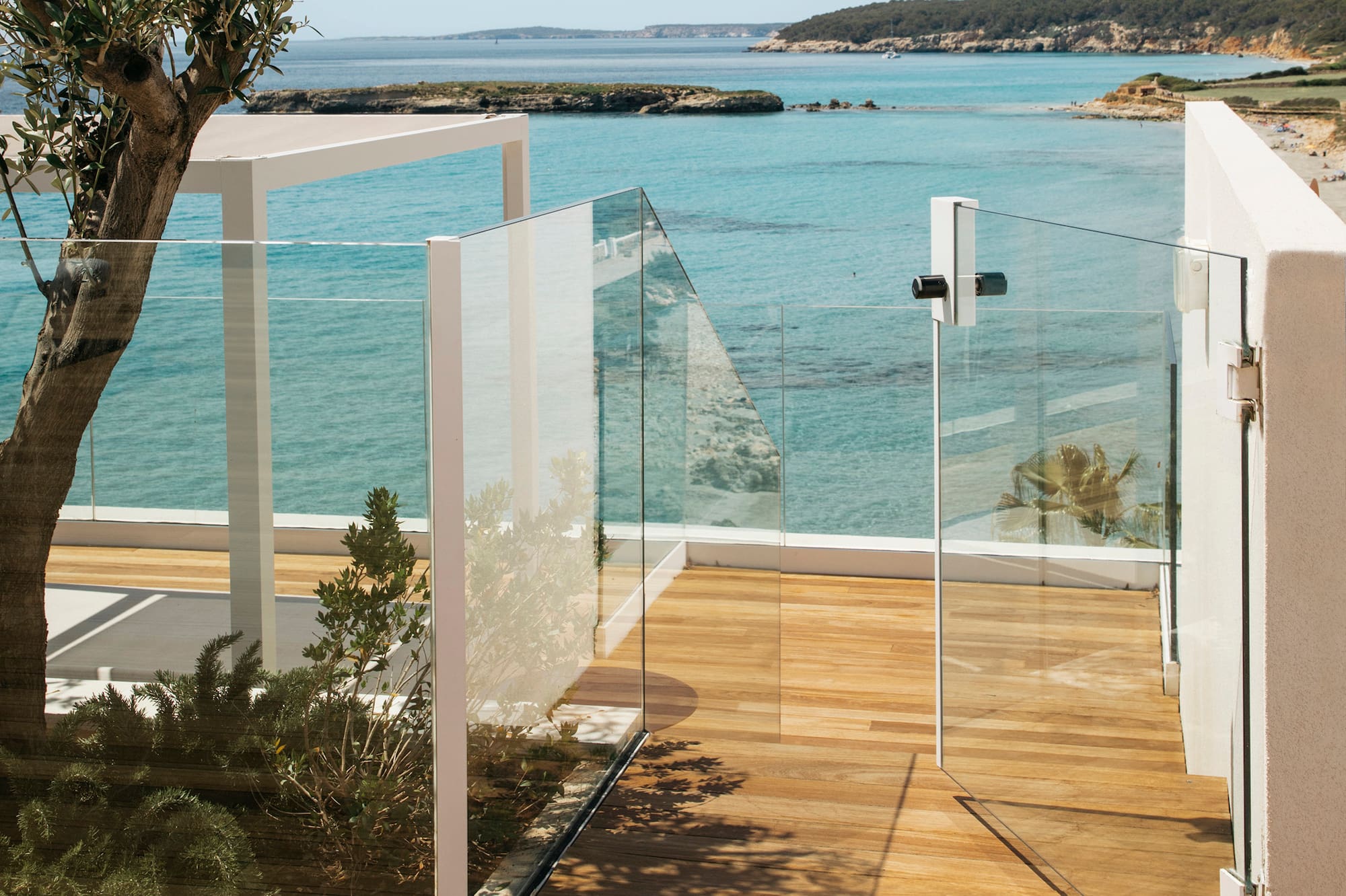 a glass fenced deck overlooking a body of water