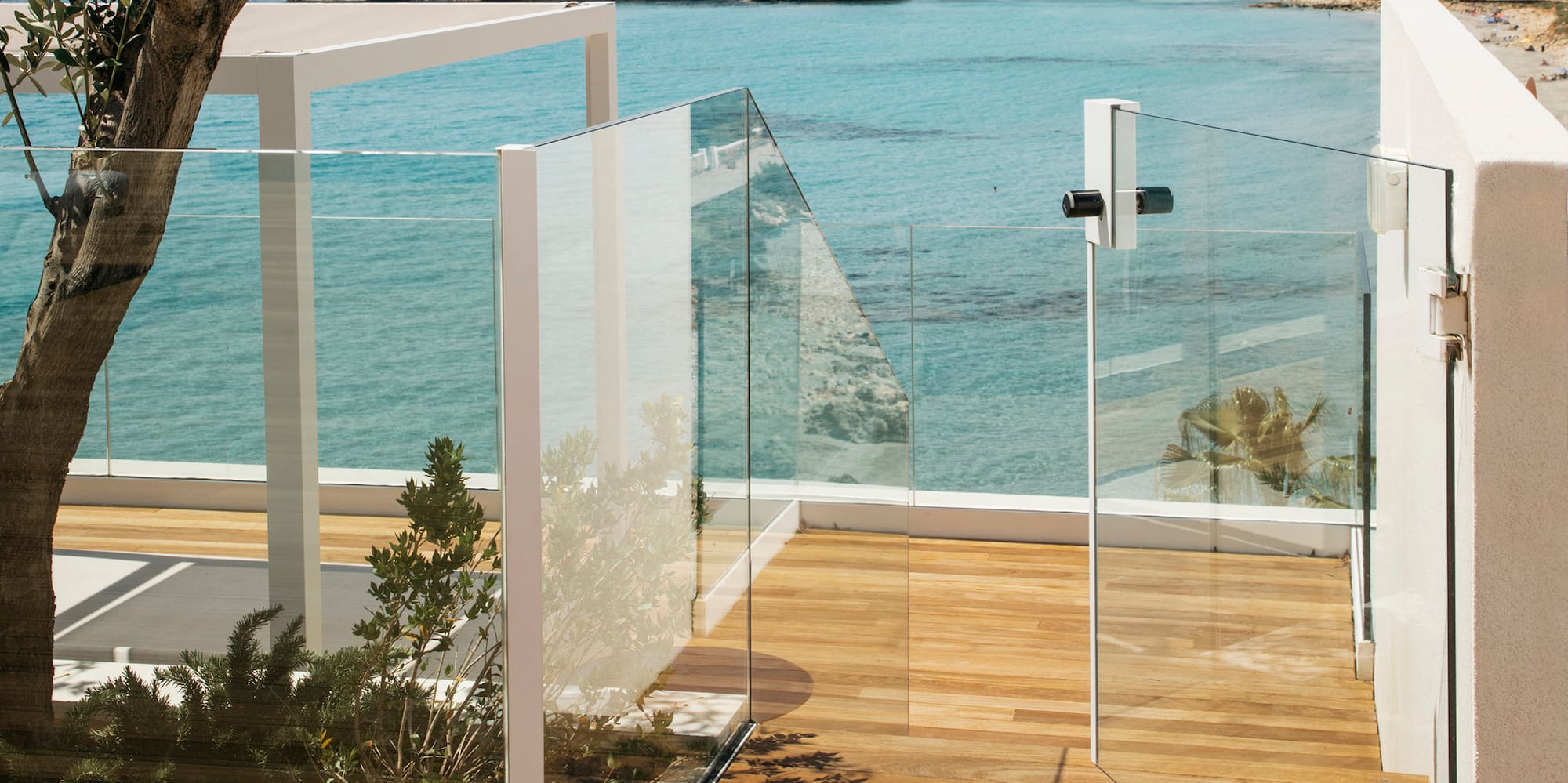 a glass fenced deck overlooking a body of water