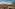 Rooftop bar with city and mountain views at sunset. Outdoor lounge.