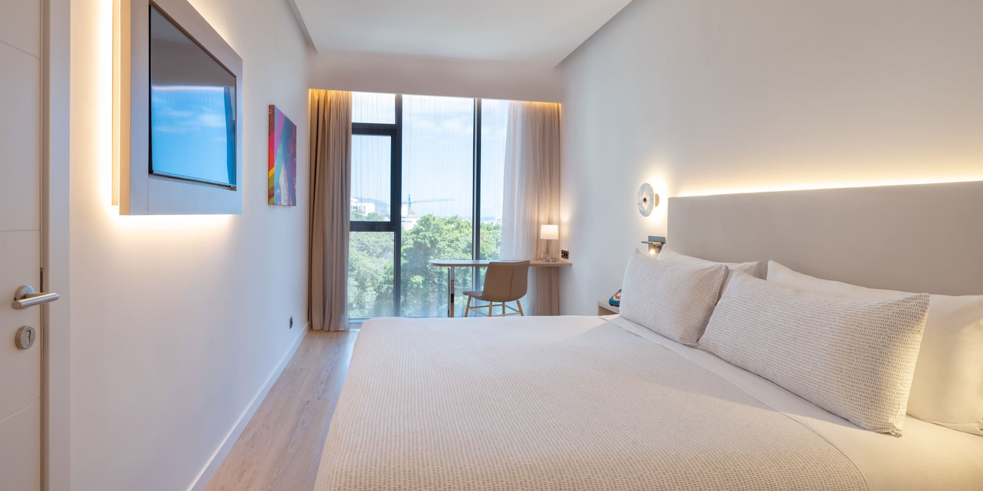 a bed in a room with a window and a table