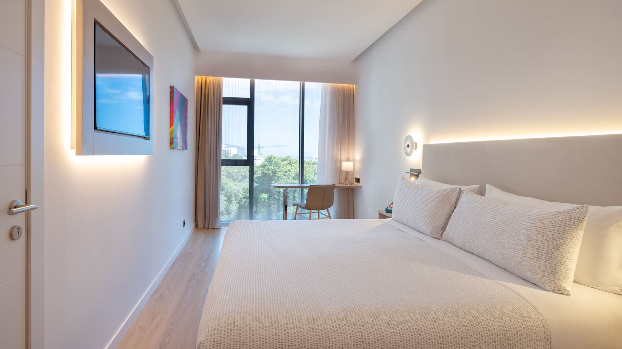 a bed in a room with a window and a table