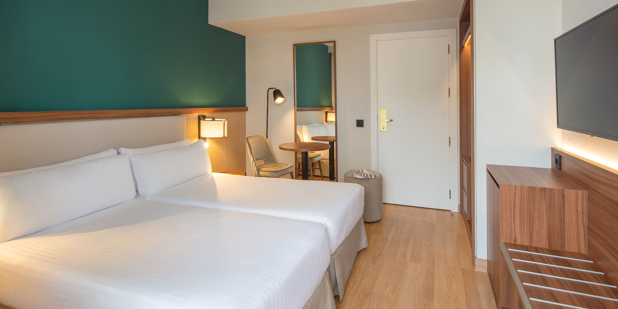 a room with two beds and a table and a chair