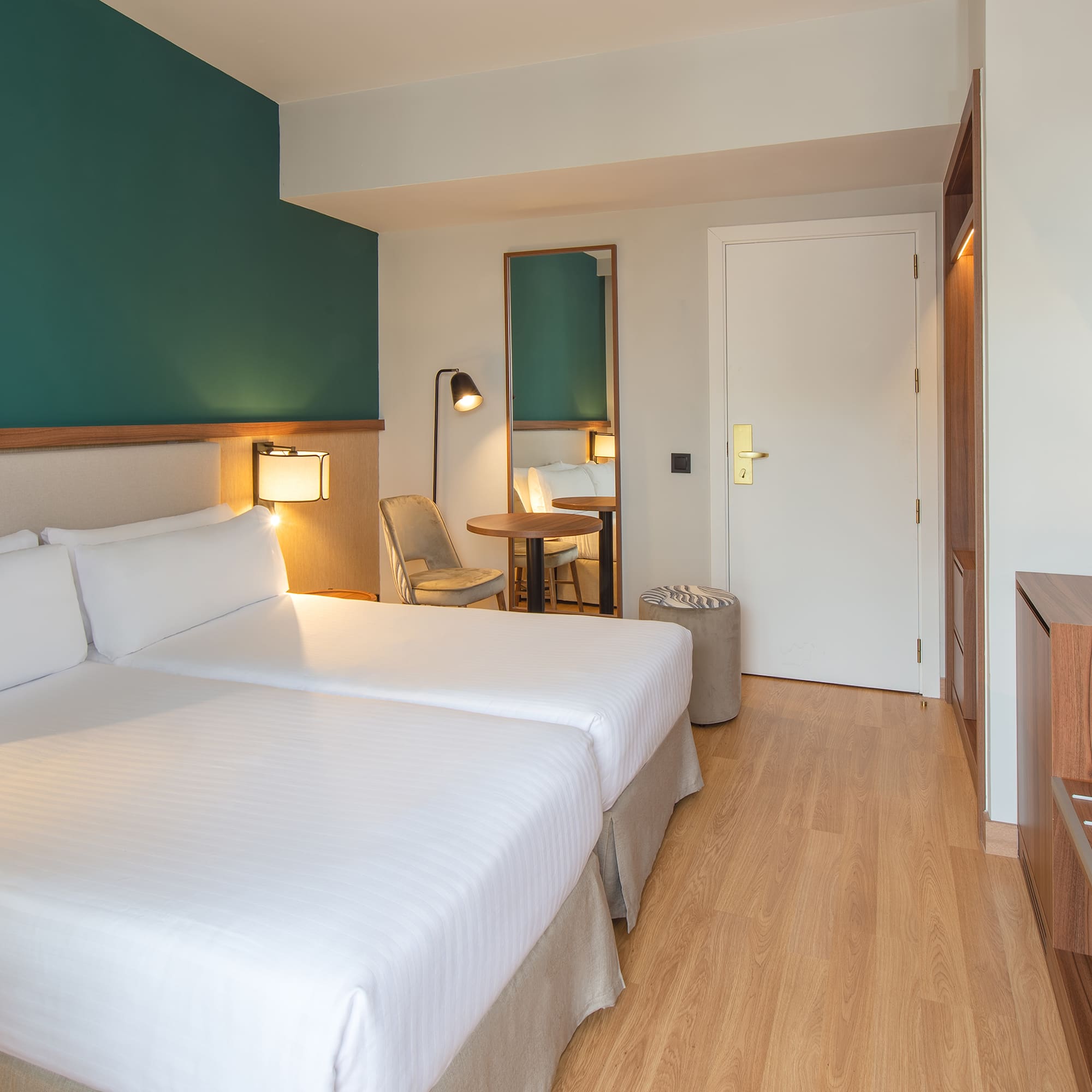 a room with two beds and a table and a chair