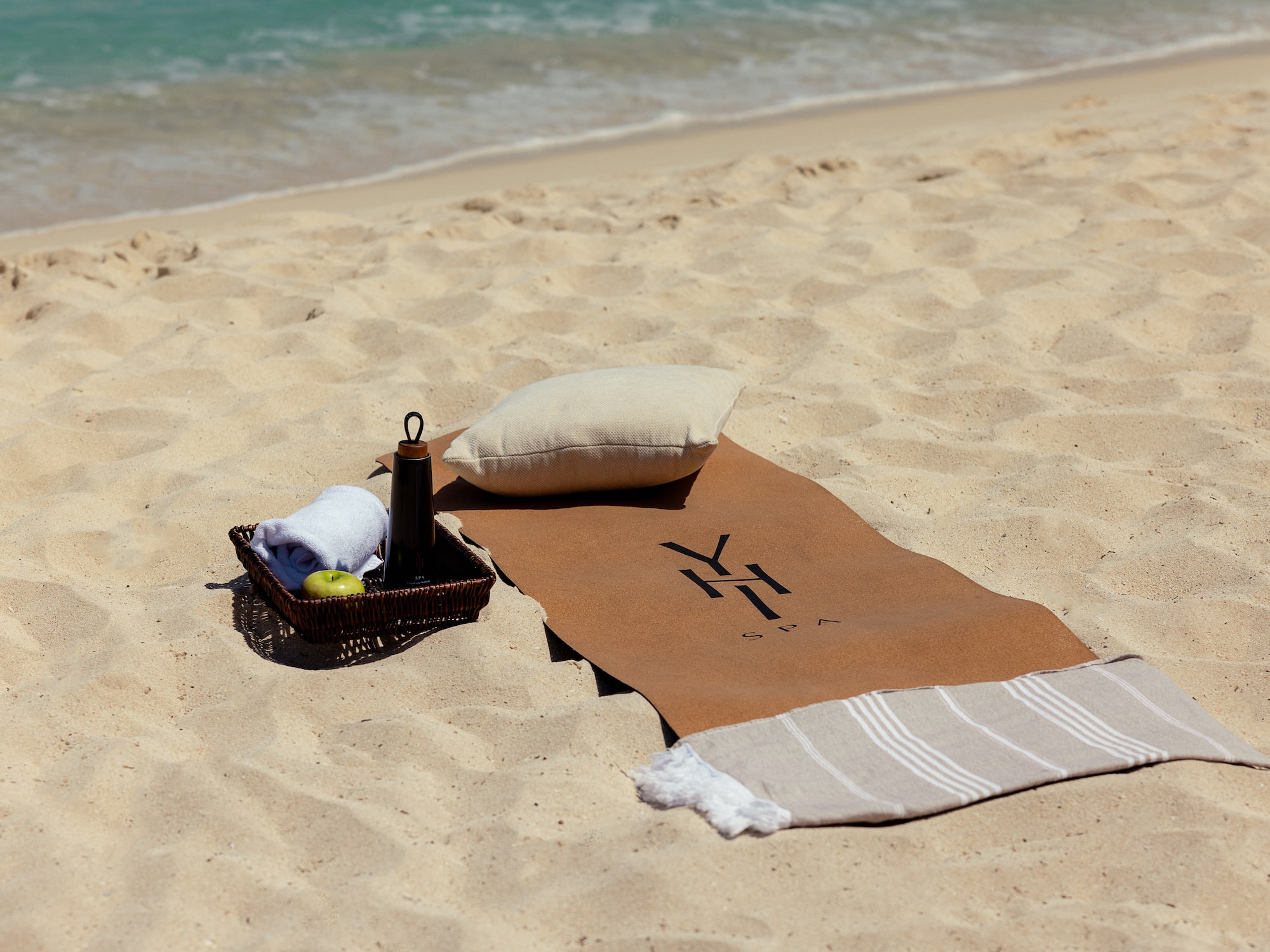 a towel and a basket on a beach