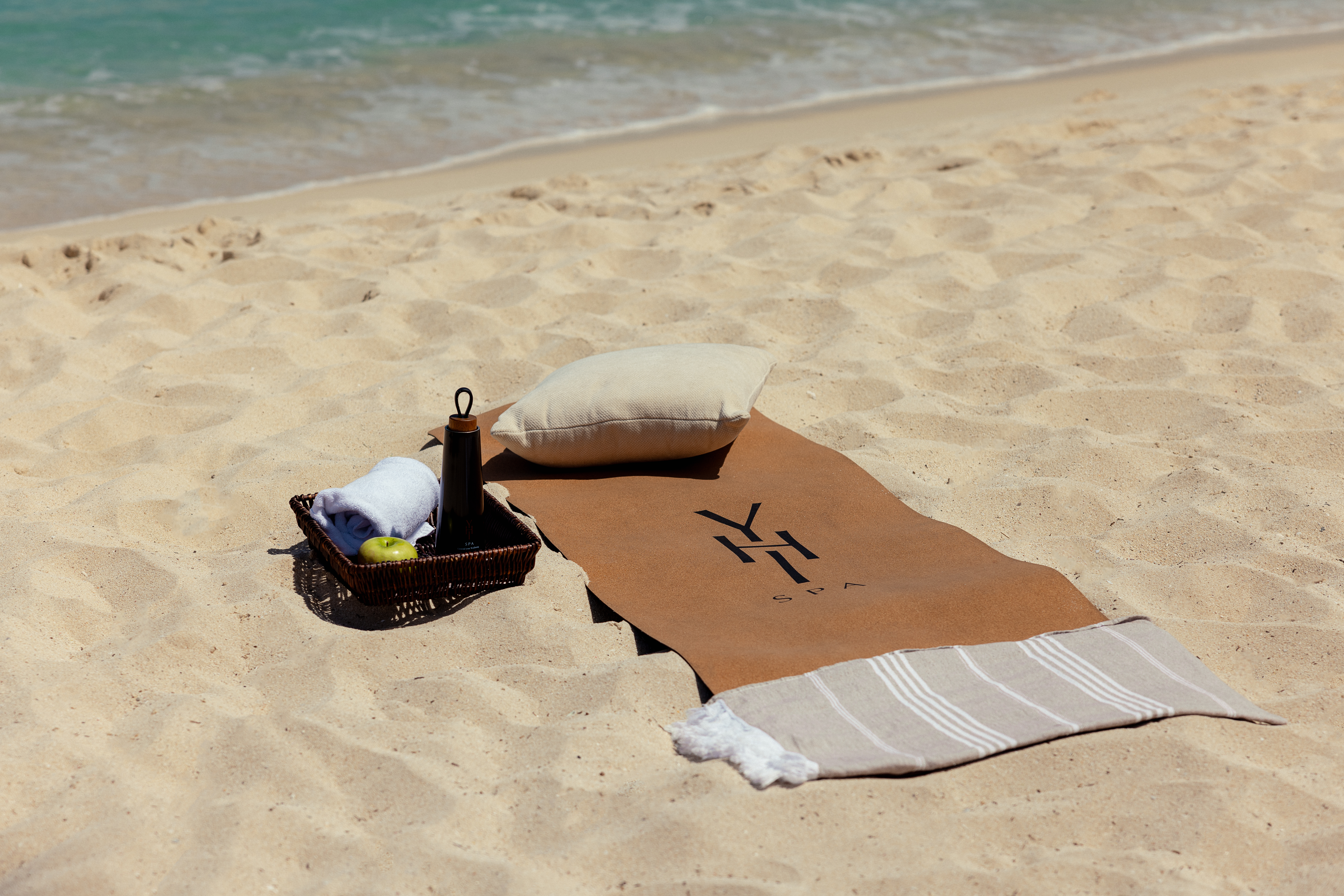 a towel and a basket on a beach