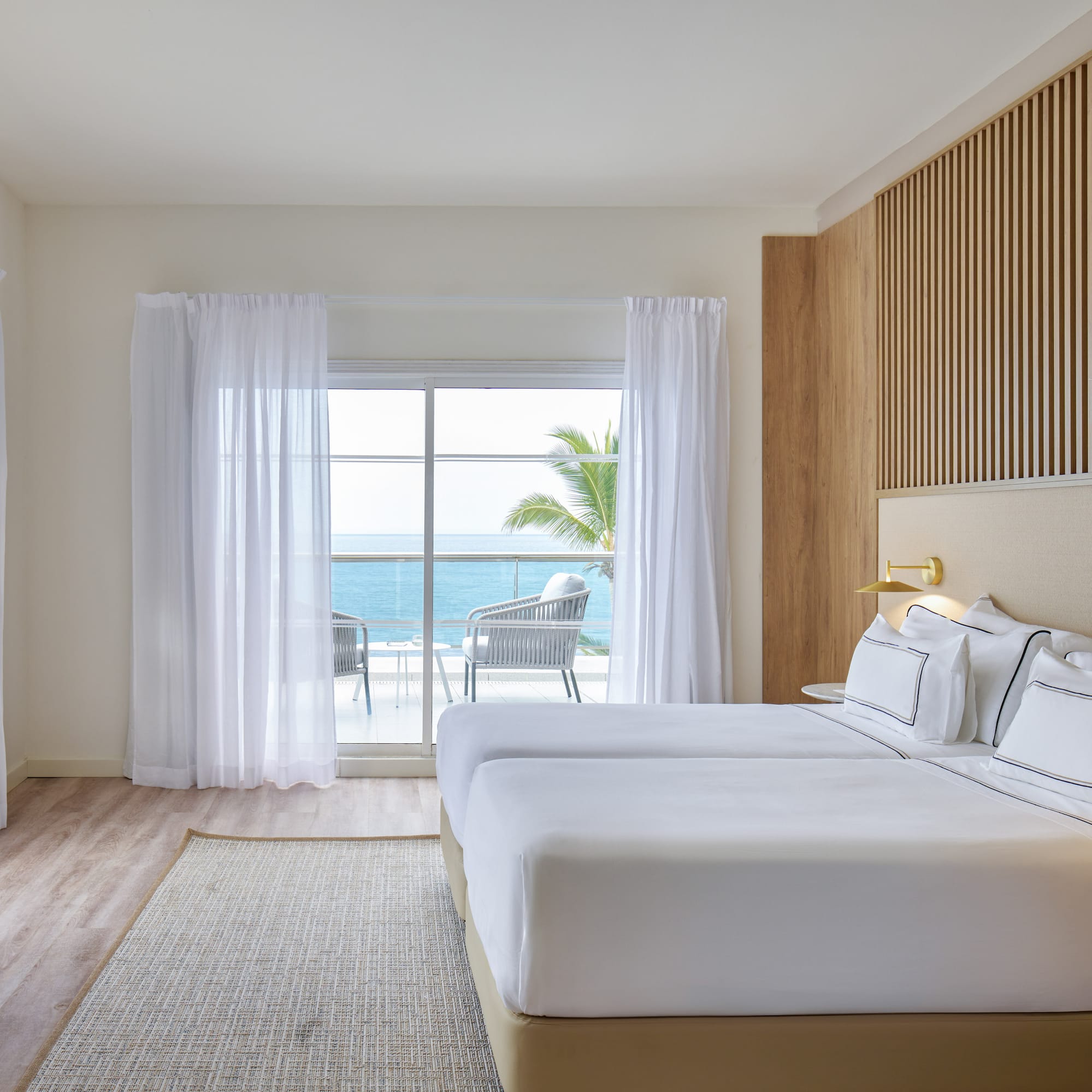 a room with a bed and a window overlooking the ocean