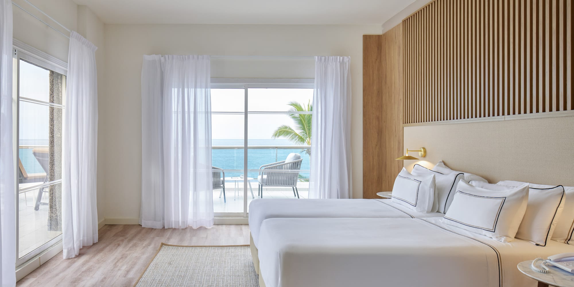 a room with a bed and a window overlooking the ocean