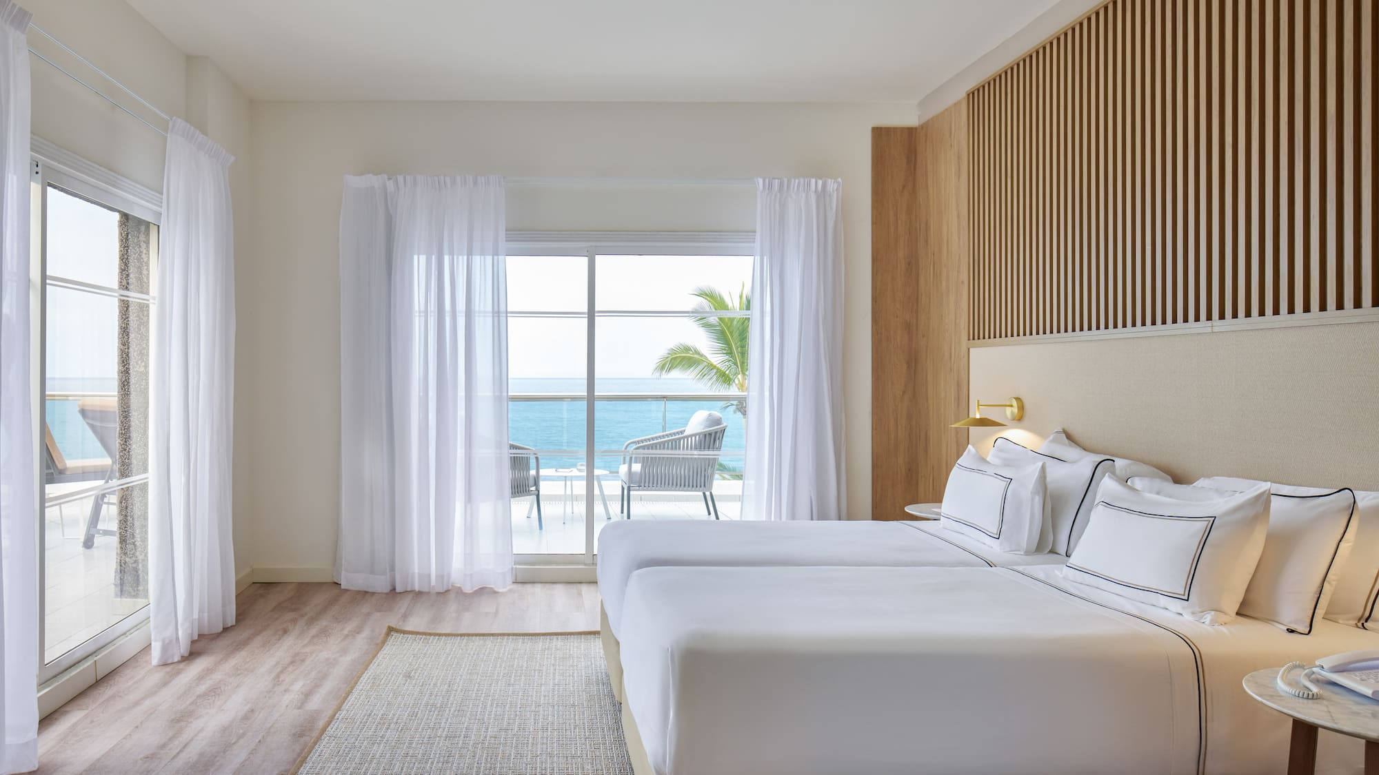 a room with a bed and a window overlooking the ocean