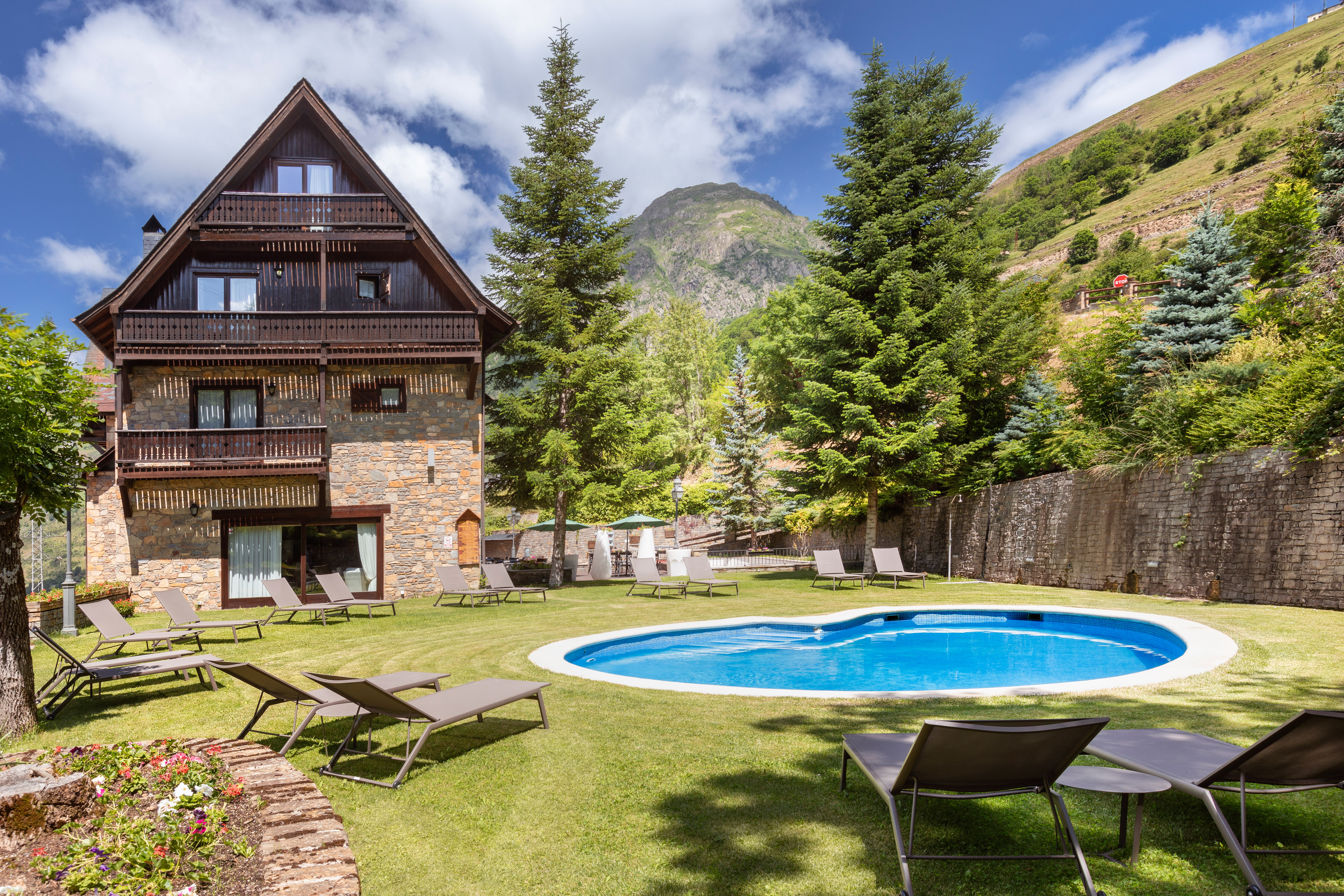 a pool in a house with chairs and trees