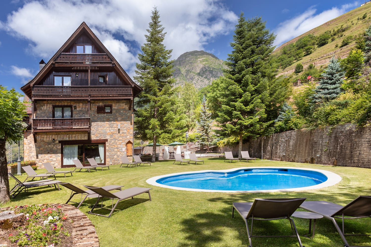 a pool in a house with chairs and trees