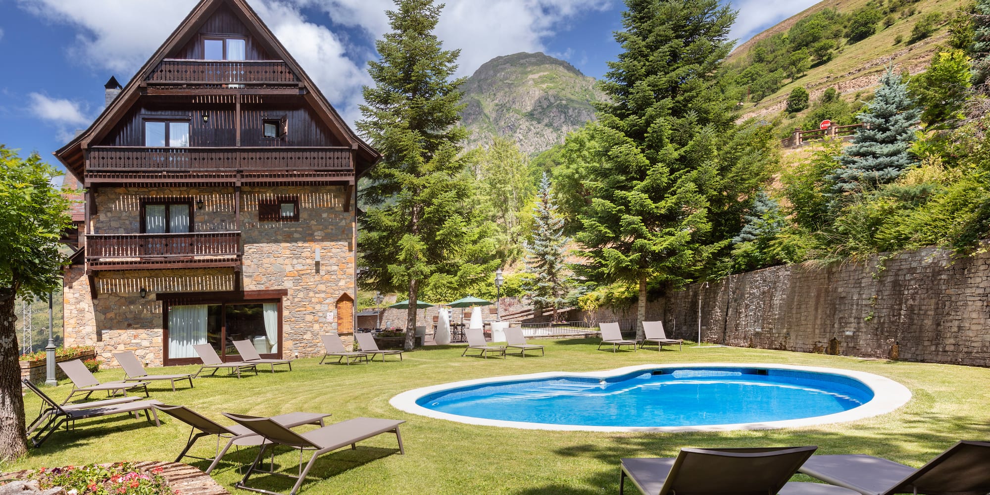 a pool in a house with chairs and trees