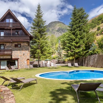 a pool in a house with chairs and trees