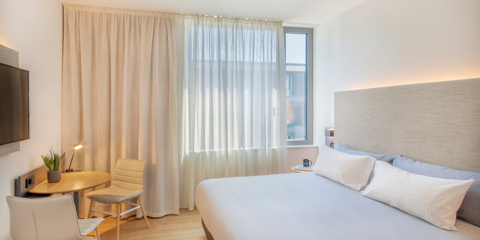 a bedroom with a bed and a table and chairs