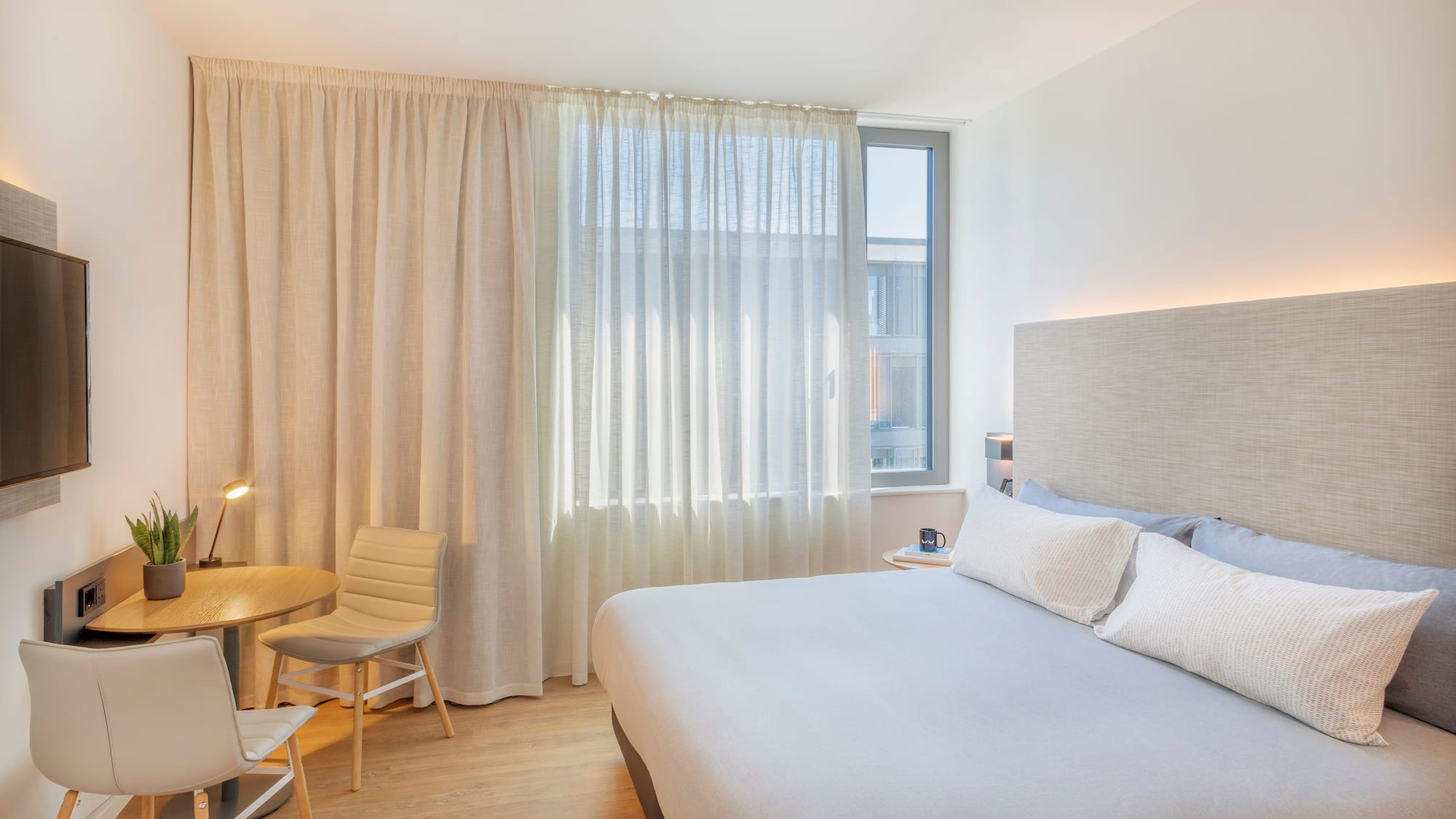 a bedroom with a bed and a table and chairs