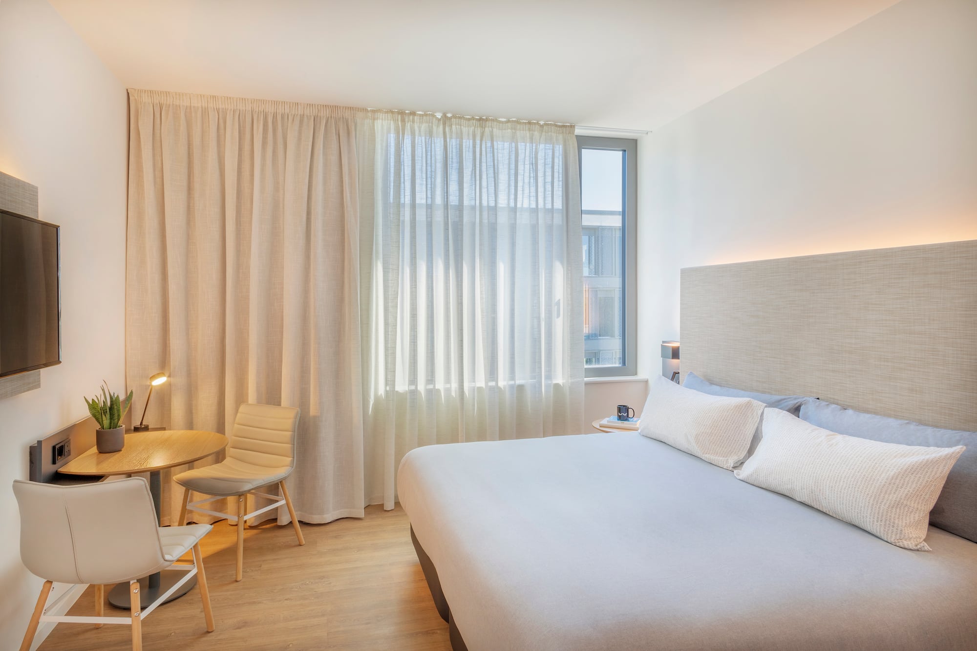 a bedroom with a bed and a table and chairs