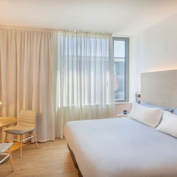 a bedroom with a bed and a table and chairs