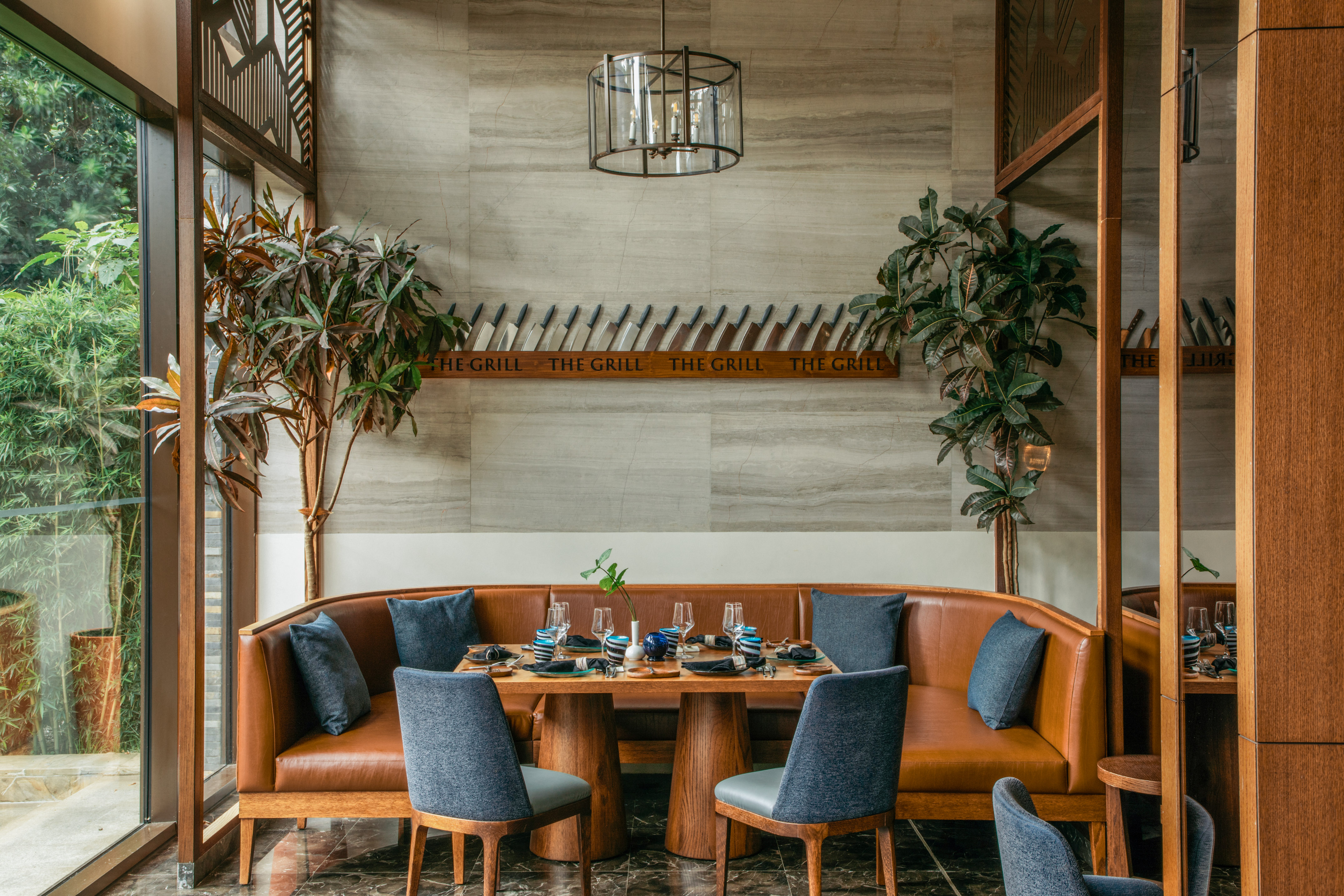 "The Grill" restaurant: modern dining room, brown leather booth, knife wall.