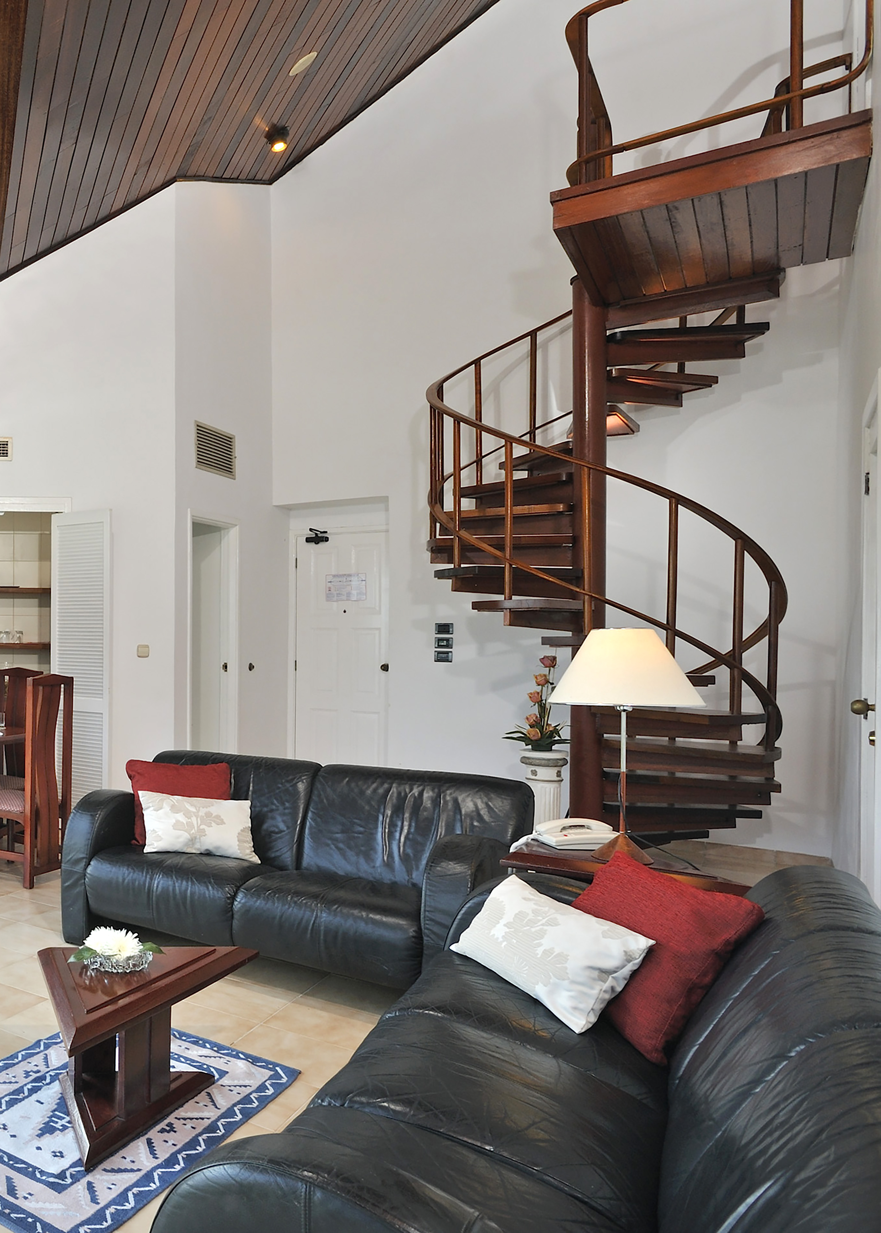 a spiral staircase in a room with a couch and a couch