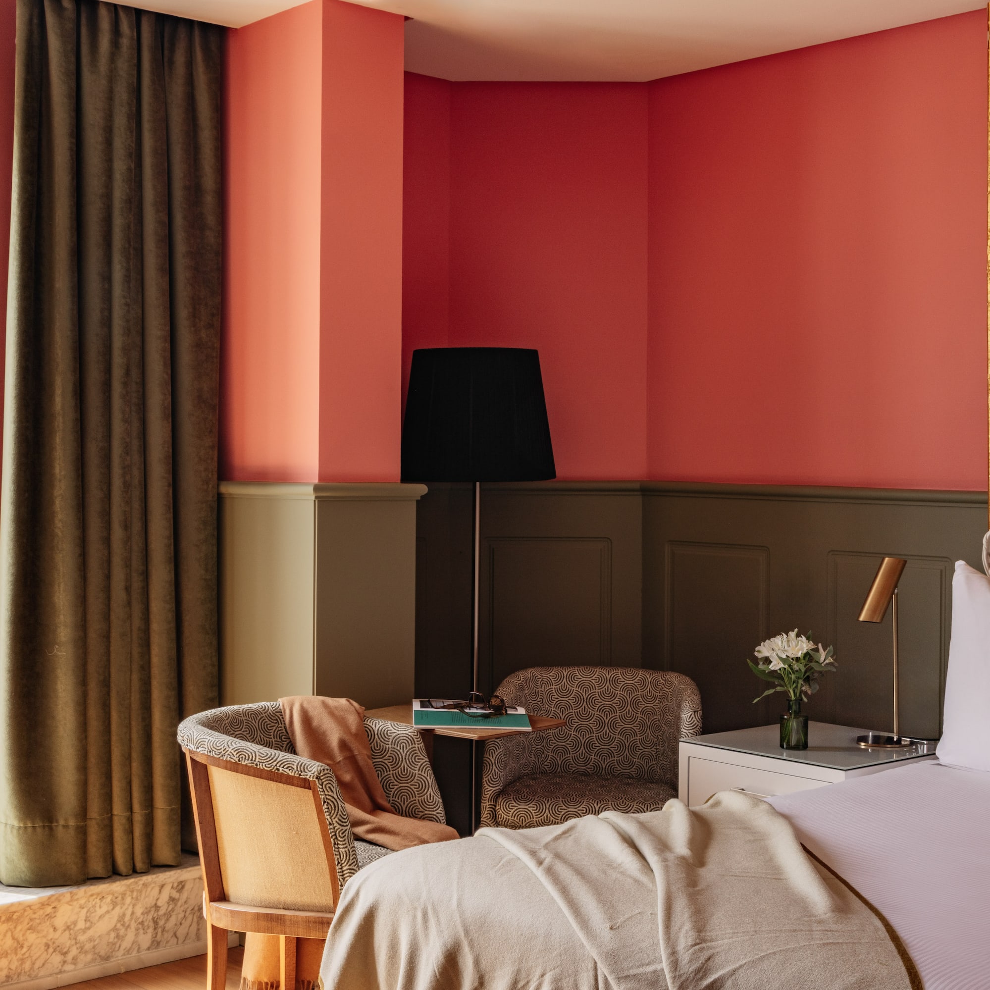 Habitación hotel con balcón, vista a cúpula, interior coral y dorado.