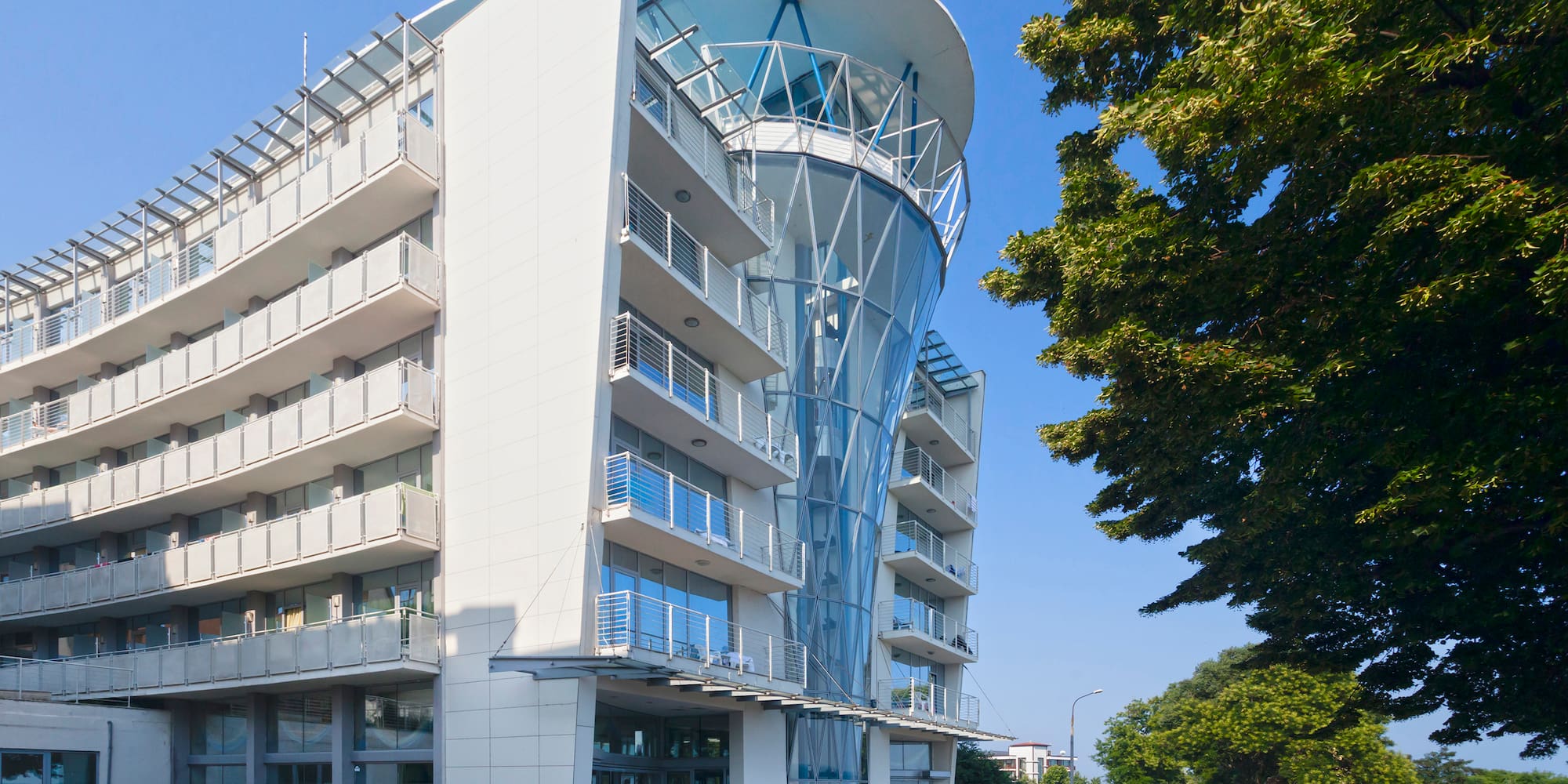 a building with a curved roof and a parking lot