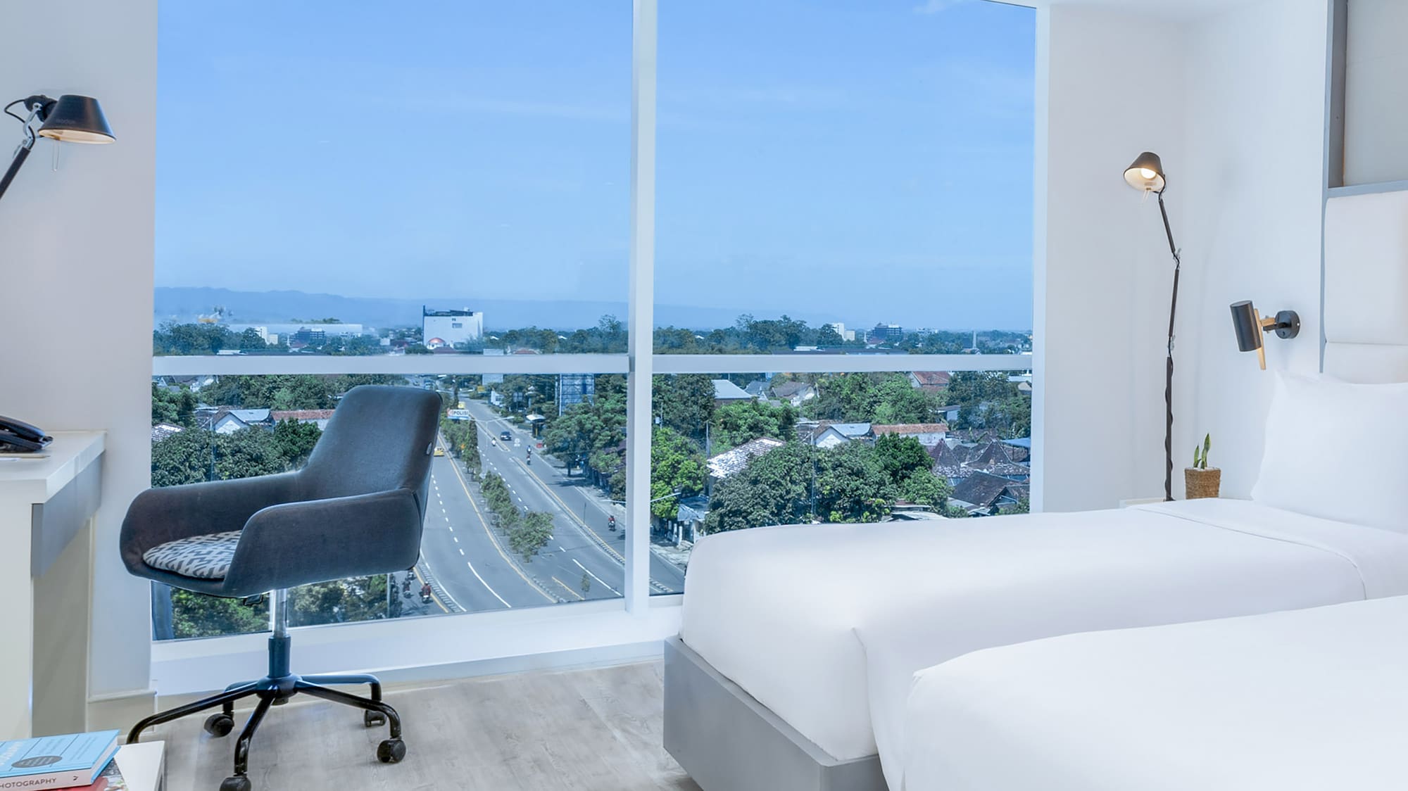 a room with two beds and a desk and a window