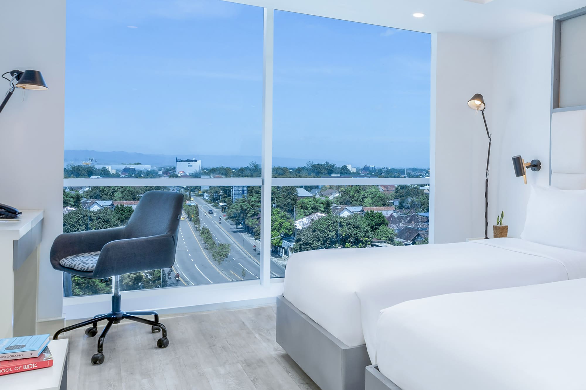 a room with two beds and a desk and a window