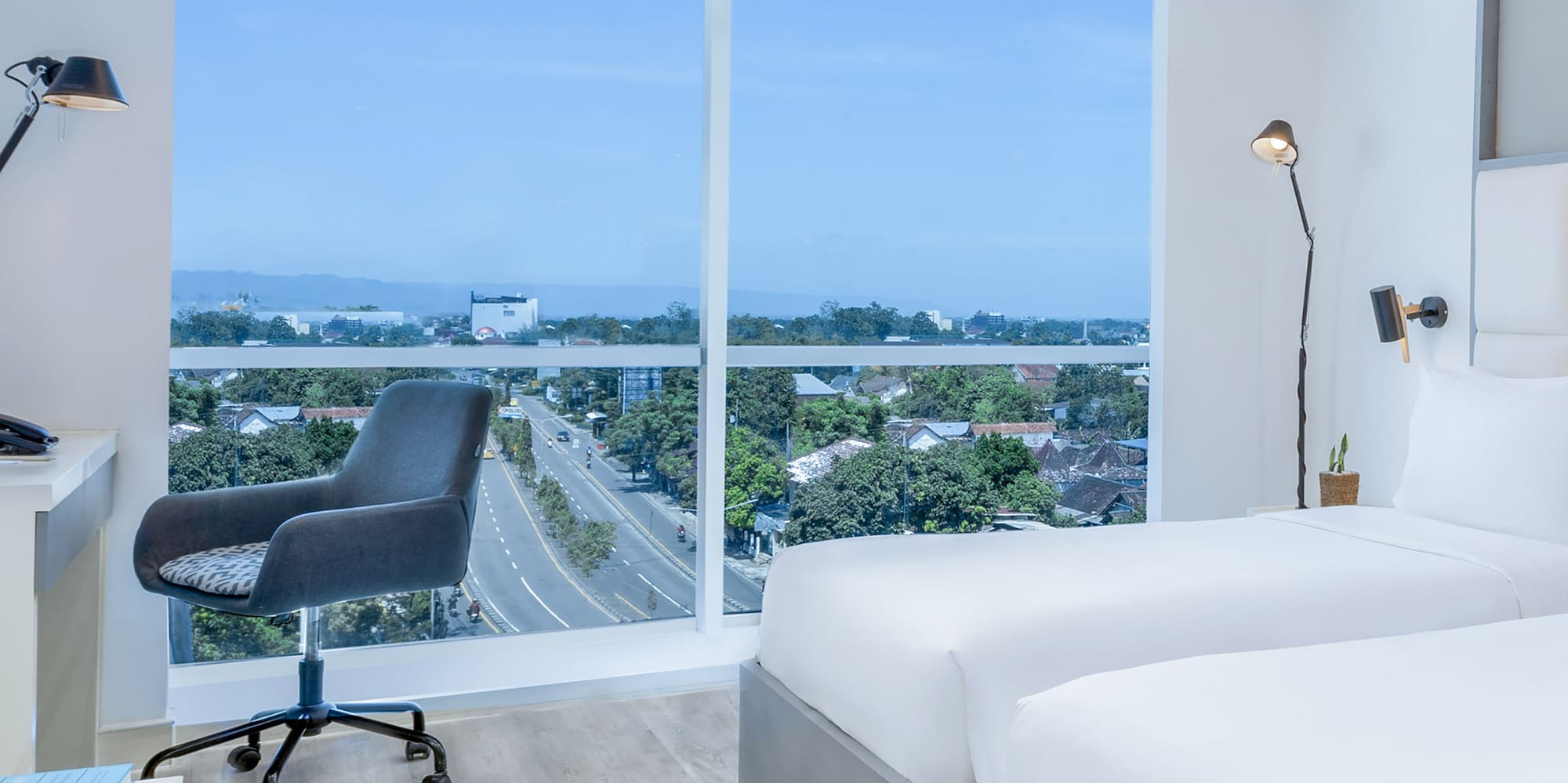 a room with two beds and a desk and a window