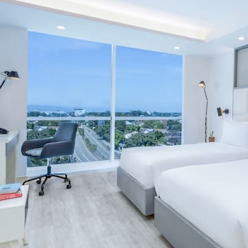 a room with two beds and a desk and a window