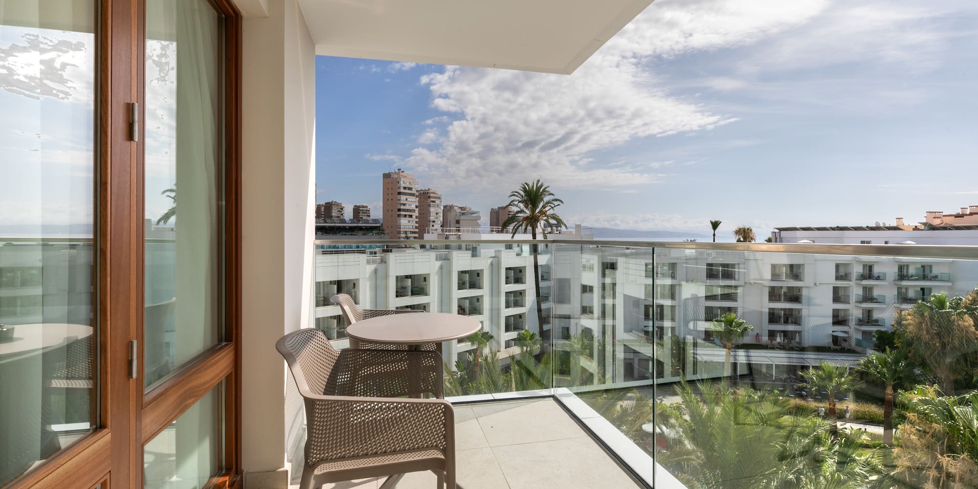 a balcony with a table and chairs and a glass railing