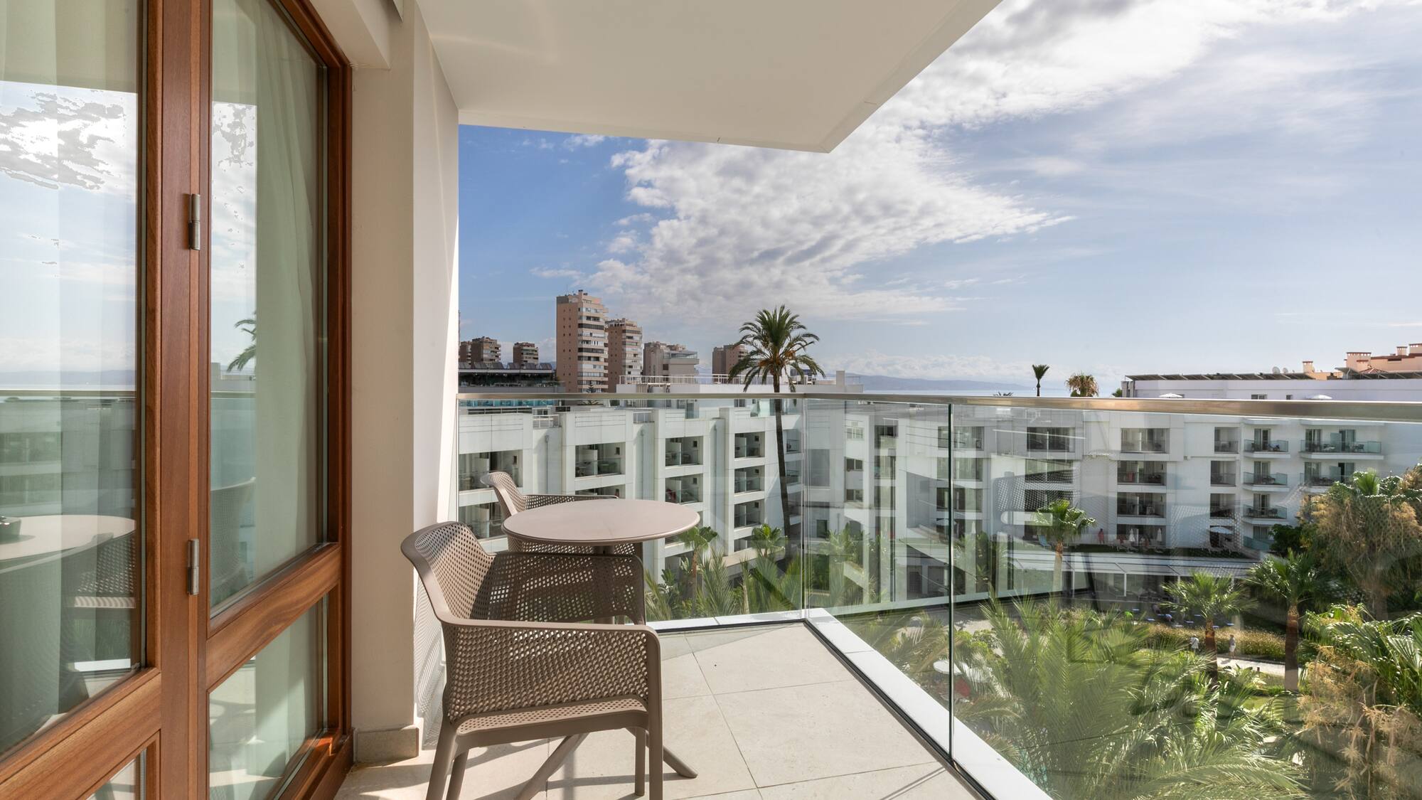 a balcony with a table and chairs and a glass railing