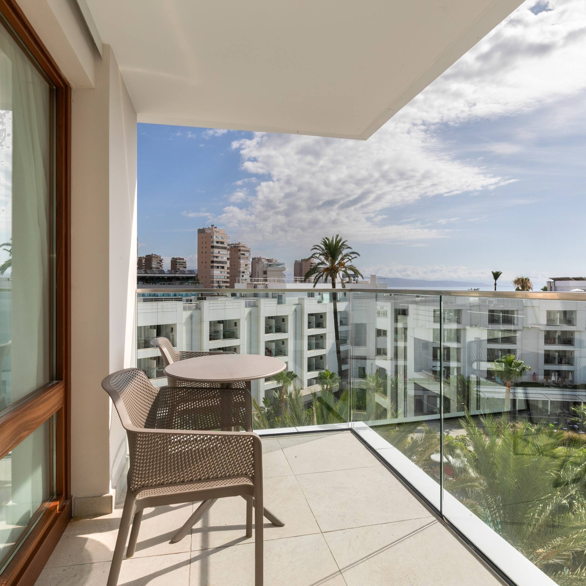 a balcony with a table and chairs and a glass railing