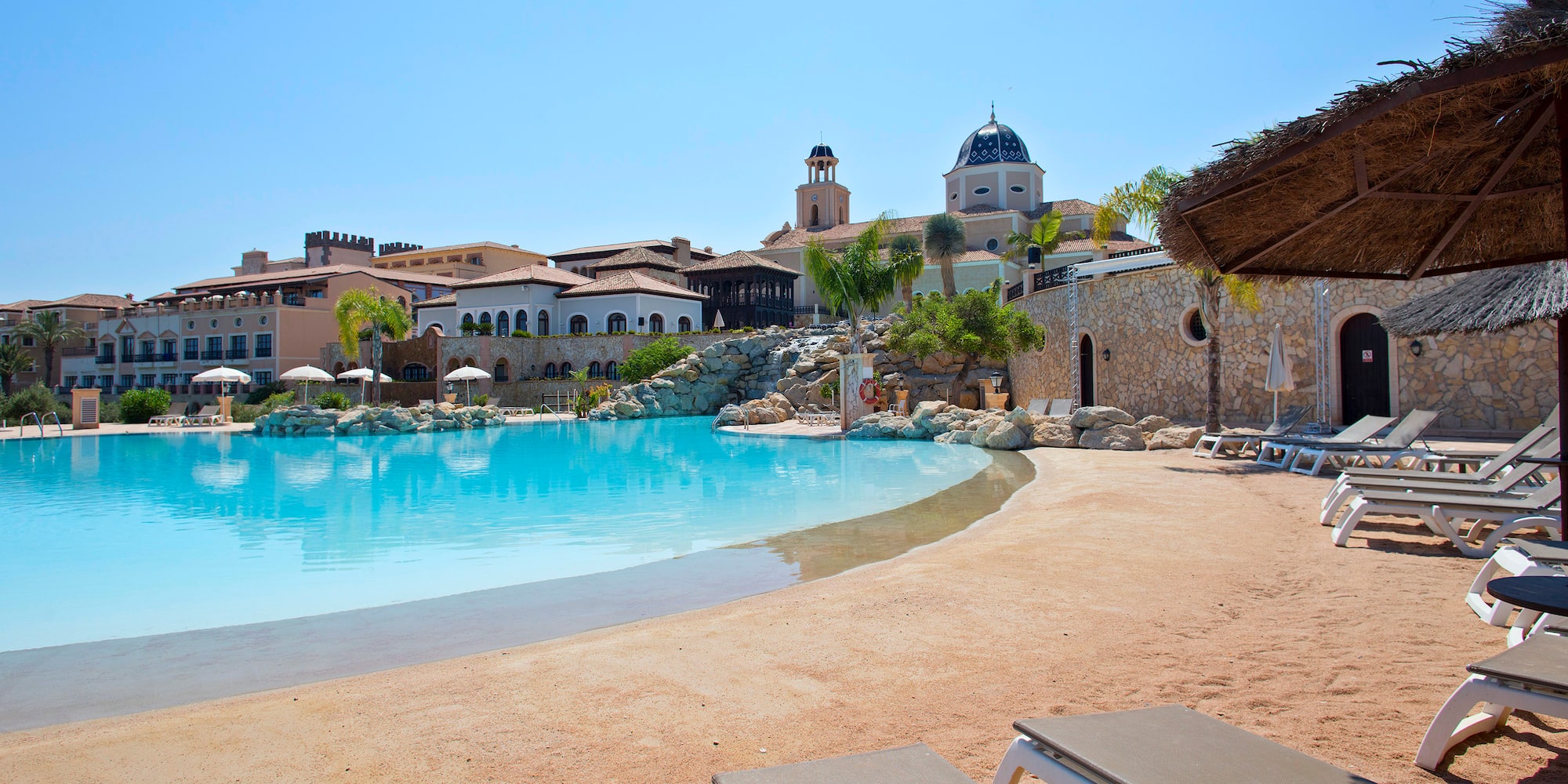 a pool with chairs and a building in the background