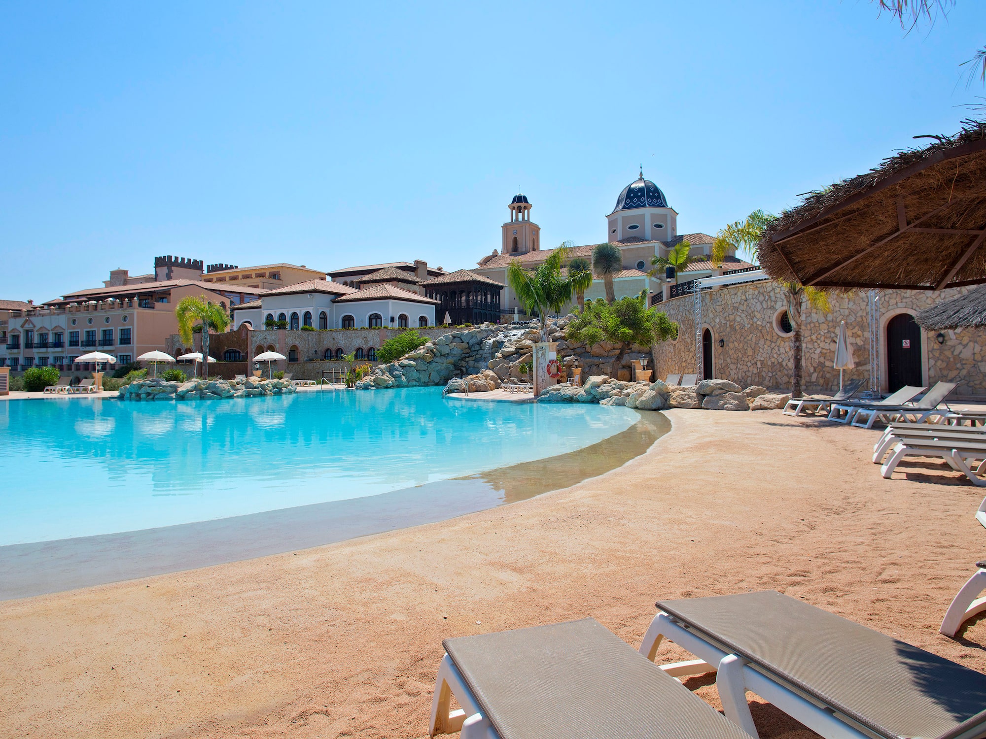 a pool with chairs and a building in the background