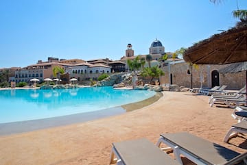 a pool with chairs and a building in the background