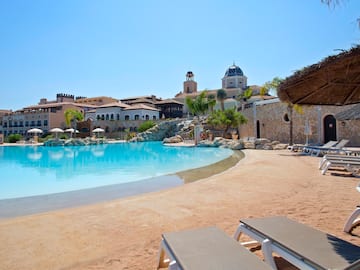 a pool with chairs and a building in the background