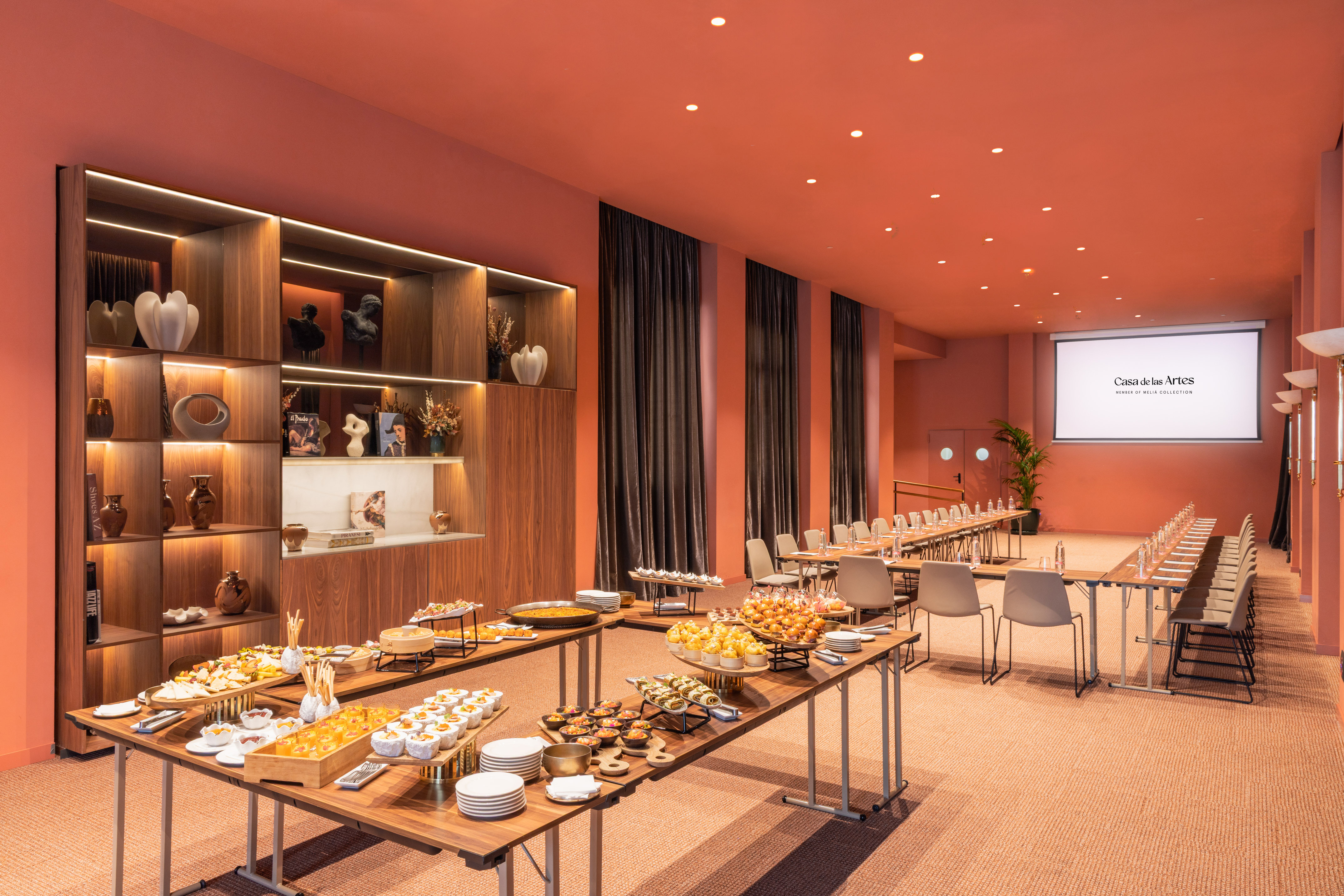 a room with tables of food and chairs