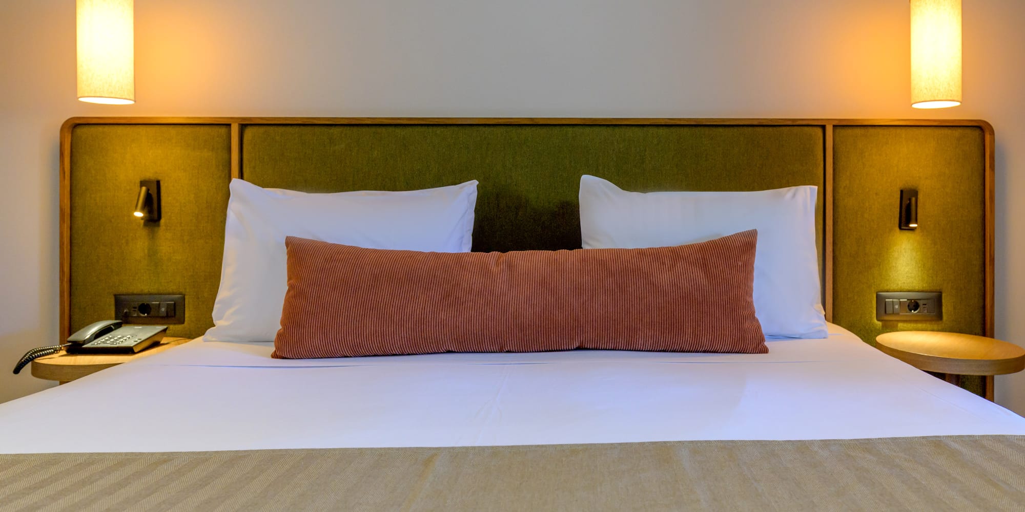 a bed with pillows and a green headboard