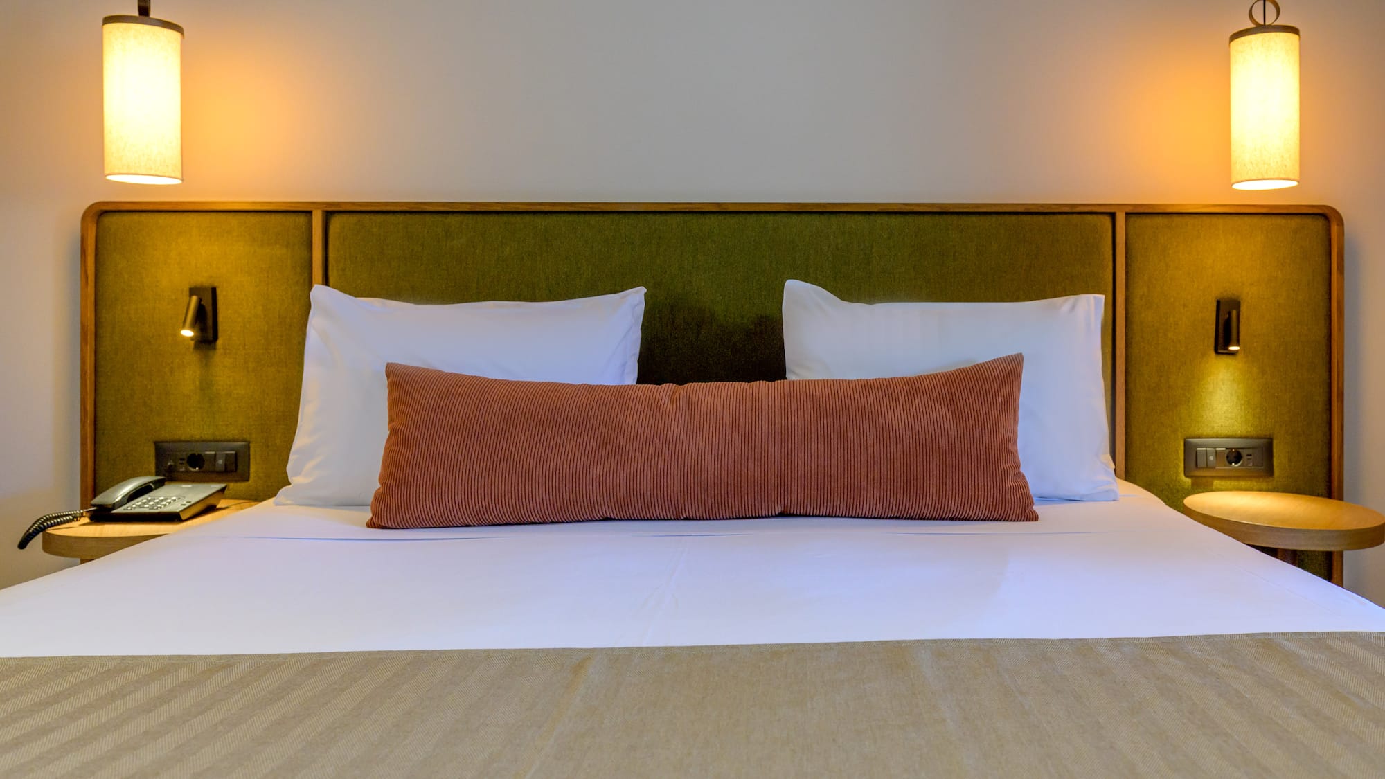 a bed with pillows and a green headboard