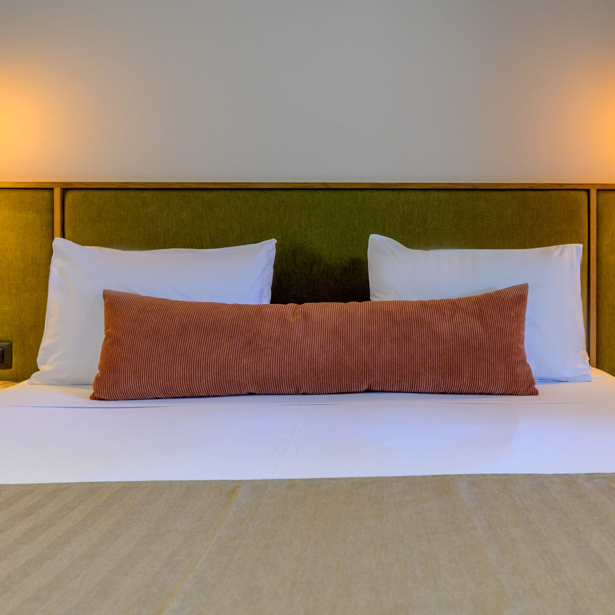 a bed with pillows and a green headboard